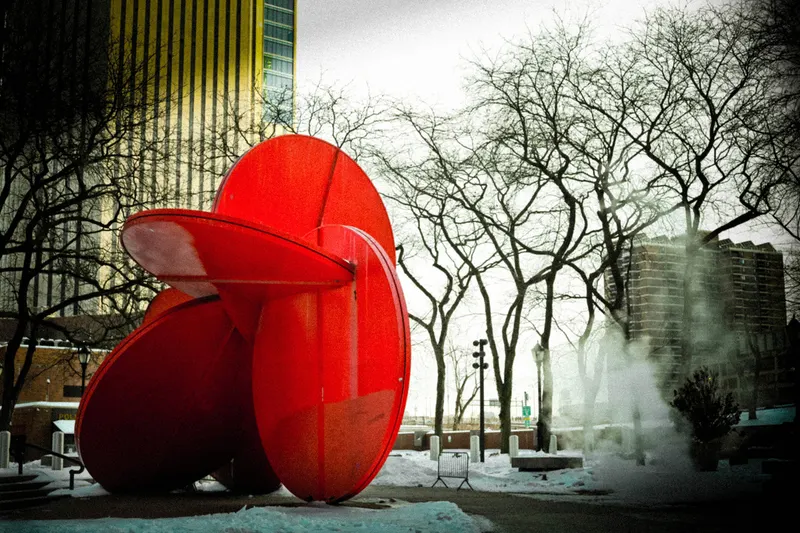 Red sculpture in a snowy New York plaza, from Polyphony